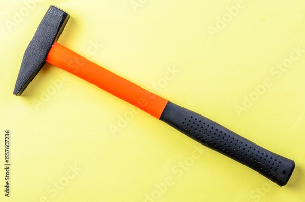 Fototapeta Hammer tool on bright yellow background isolated closeup sharp image