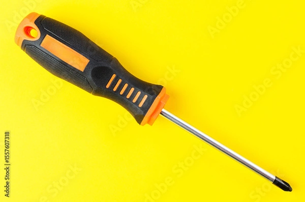 Fototapeta Cross-head screwdriver on bright yellow background isolated closeup sharp image