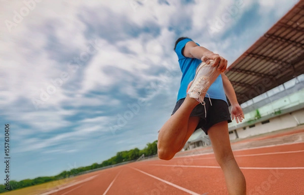 Obraz Runner Stretching Leg on Track Field