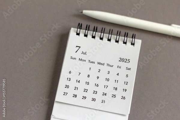 Fototapeta A desktop calendar for July 2025 on a desk with space to copy.