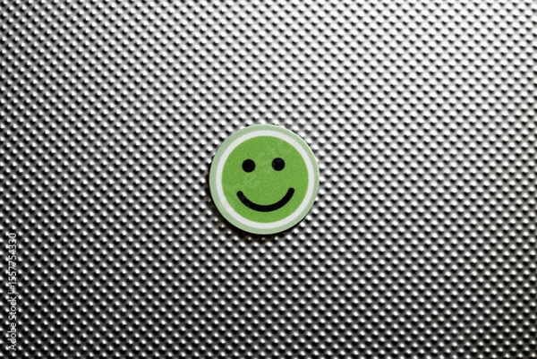Fototapeta round emoji face in green color, representing happy emotions on a metallic textured background, symbolizing feedback of satisfaction and positive answer
