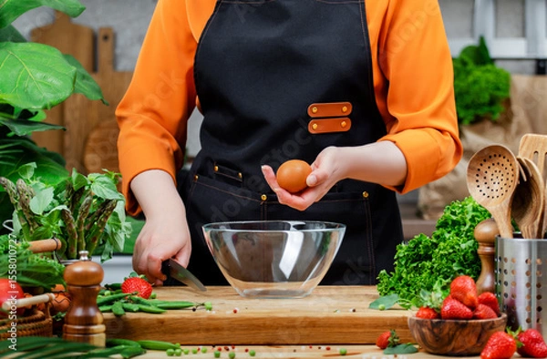 Fototapeta Healthy cooking with fresh vegetables and eggs by a passionate chef in a vibrant kitchen filled with greenery and culinary tools