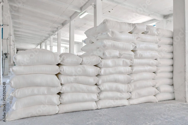 Fototapeta Wheat flour bags stacked in a bright warehouse with a clean and organized layout