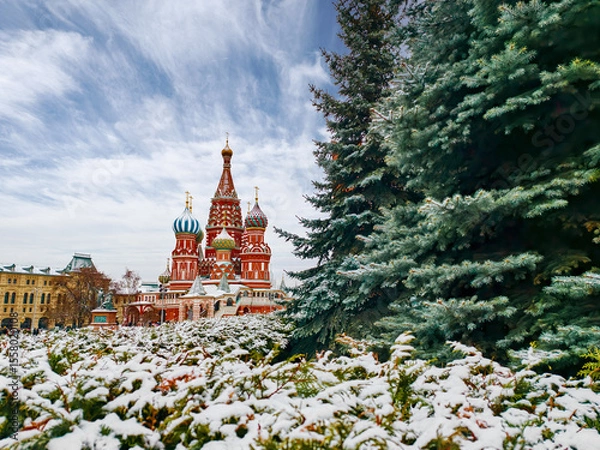 Fototapeta Winter wonderland surrounds the iconic St. Basil's Cathedral in Moscow as snow blankets the vibrant architecture and evergreen trees