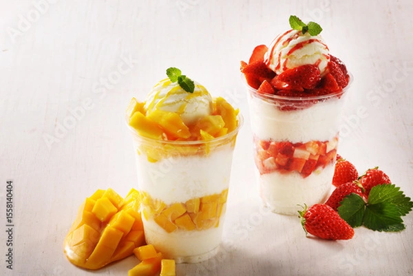 Fototapeta 일회용 컵에 담긴 시원하고 달콤한 애플망고 눈꽃 빙수와 생딸기 눈꽃 빙수.