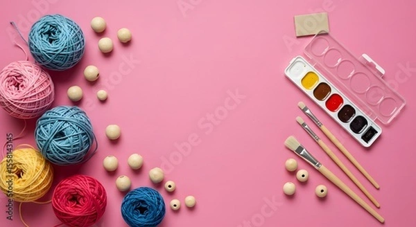 Fototapeta Craft supplies on pink colorful yarn, wooden beads, watercolor paints, brushes. Essential art and craft materials for creative hobbies, DIY projects.