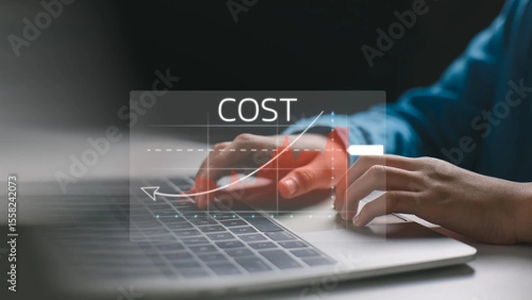 Obraz A close-up of a person typing on a laptop with a cost analysis graph overlay, illustrating rising expenses or cost management. Ideal for finance, business strategy, and data analytics themes.
