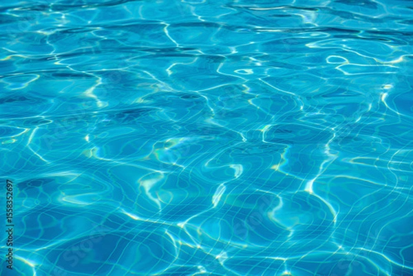 Obraz The clear blue surface of swimming pool water reflecting light caustic pattern.