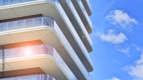 Fototapeta Exterior of a high modern multi-story apartment building - facade, windows and balconies.