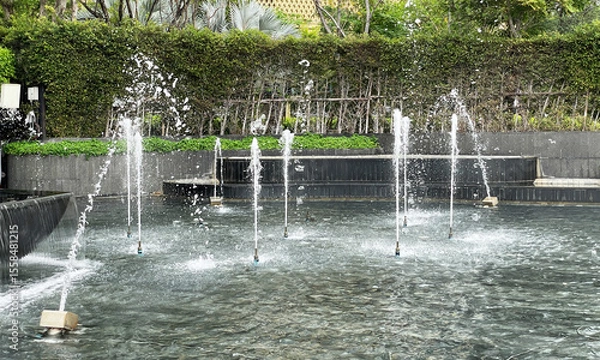 Fototapeta Fountain dancing on public park show bubbles of water coming out of the water nozzle.