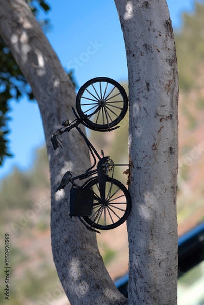 Fototapeta Miniature vintage bicycle decor pinned on tree trunk