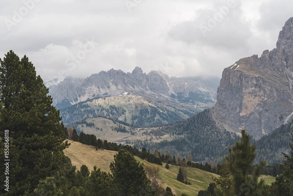 Fototapeta Mountain view with cloudy sky and forest in Dolomites, Italy.