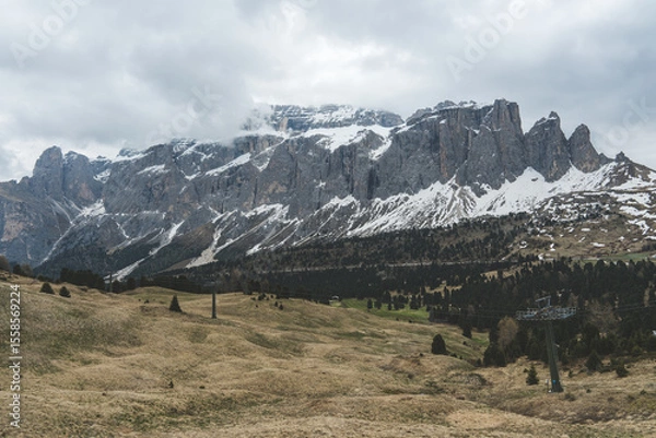 Fototapeta Mountain range of Sella Group with snow and cloudy sky in Dolomites, Italy.