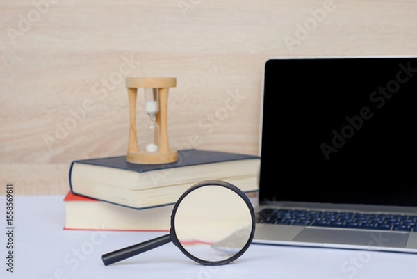 Fototapeta Its the perfect time for focused study with a laptop, books, and an hourglass for productivity