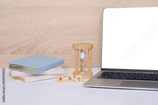 Fototapeta A workspace feature showcasing a laptop and hourglass, designed to boost productivity