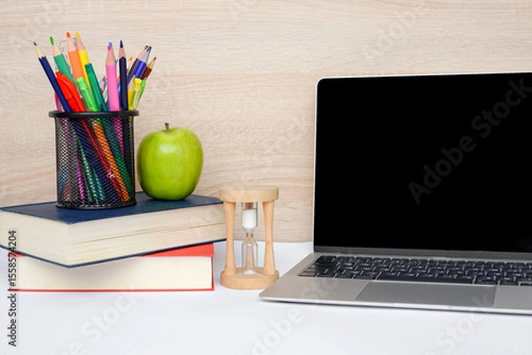 Fototapeta A dedicated study space featuring a laptop, books, and a fresh apple for inspiration