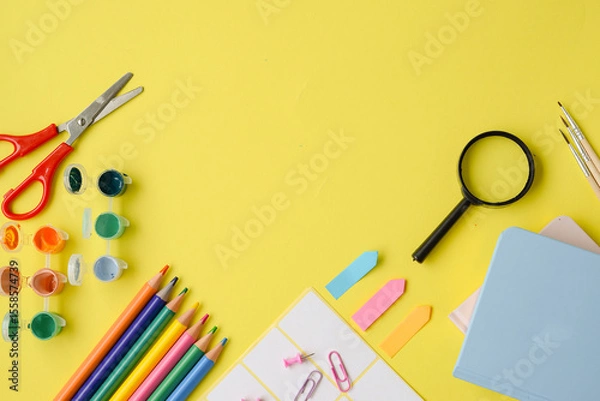 Fototapeta A Creative Workspace Filled with Colorful Art Supplies Set Against a Yellow Background