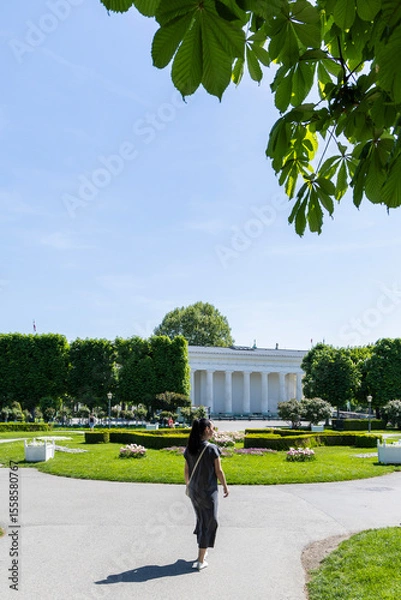 Obraz Female tourist looks at the Austrian Parliament building. View from the back. Austria, Vienna