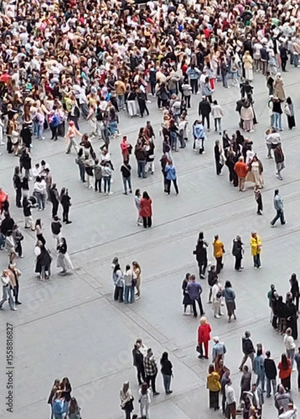 Fototapeta Aerial view of large crowd of people standing in small groups on urban square