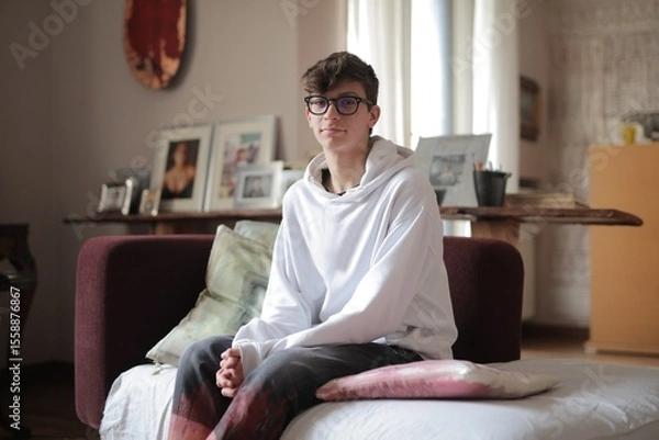 Obraz young man sitting on a sofa at home
