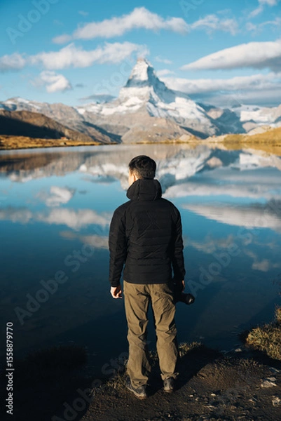 Fototapeta Man standing with camera at Lake Stellisee with Matterhorn mountain in Switzerland