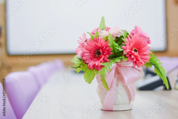 Fototapeta Flowers in a vase on a table in a conference room