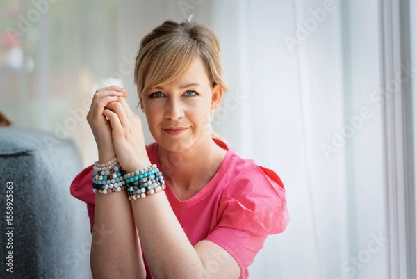Obraz Blond haired woman sitting next to the window