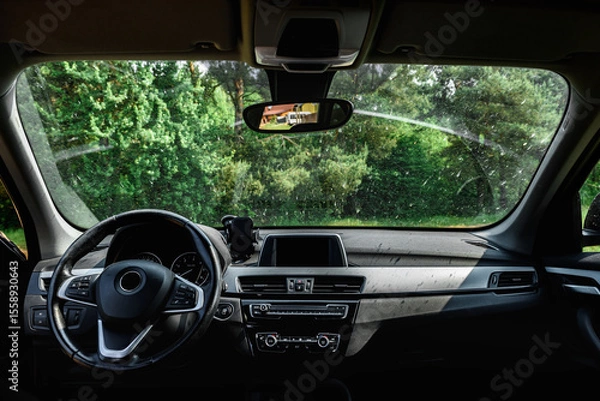 Fototapeta Smeared and dirty front windshield of a vehicle after hitting bugs.