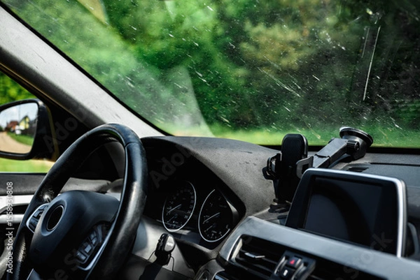 Fototapeta Smeared and dirty front windshield of a vehicle after hitting bugs.