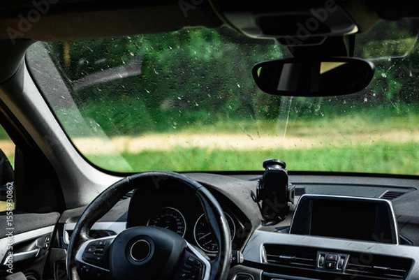 Fototapeta Smeared and dirty front windshield of a vehicle after hitting bugs.