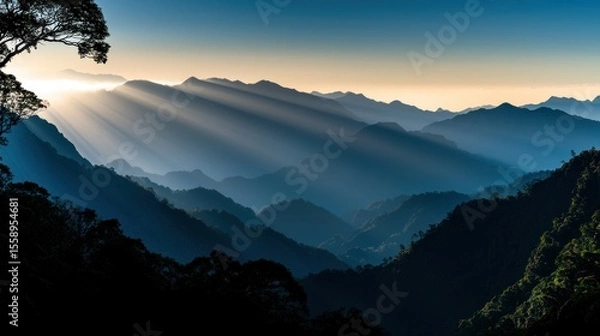 Fototapeta Sunlight shining through mountain ranges creating a beautiful landscape scene