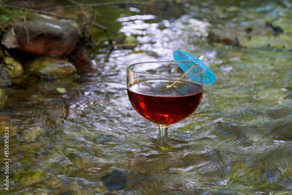 Fototapeta Rotes Getränk im sommerlichen Bach