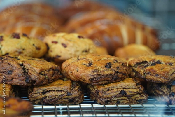 Obraz Close-Up of Delicious Chocolate Chip Scones and Raisin Cookies in a Bakery Display