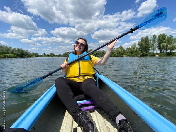 Fototapeta Happy woman in kayak with paddle, summer day, kayaking on the river.