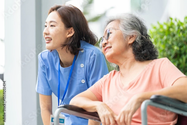 Fototapeta An empathetic caregiver crouches to listen to a senior woman in a wheelchair, demonstrating respect and building trust. A concept for patient-centric communication and holistic health.