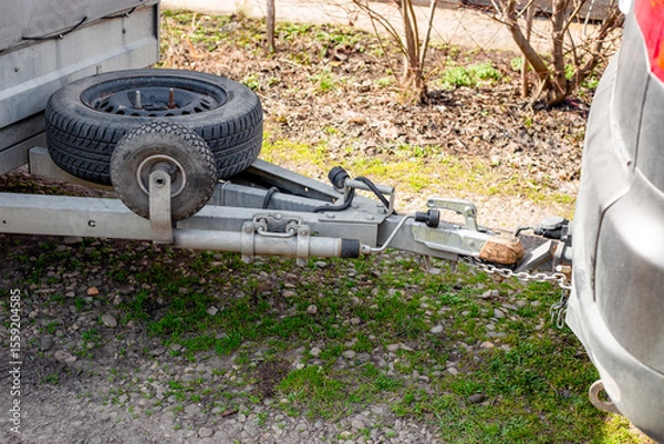Fototapeta A car hitch is connected to a trailer whose spare tires are attached to the trailer frame