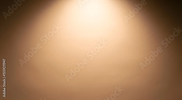 Fototapeta Warm golden spotlight shining on a smooth brown gradient background. Abstract studio lighting concept for product display.
