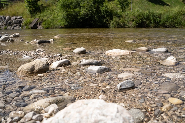 Fototapeta Clear mountain stream with pebbles and rocks in summer
