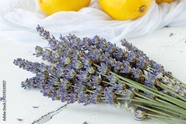 Obraz Bunch of lavender flowers with lemon fruit in the background. Close-up.