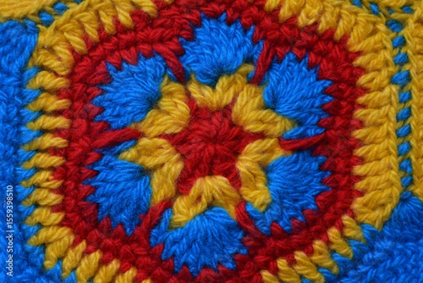 Fototapeta Yellow and red crochet rug. Handmade product made of woolen threads.