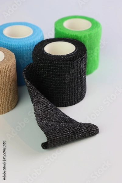 Fototapeta Different colors of cohesive bandages. Non adhesive bandage in a white background with different colors