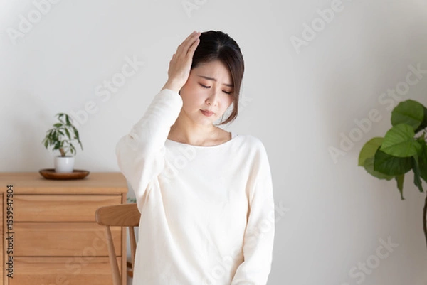 Obraz 頭痛で頭を押さえる女性