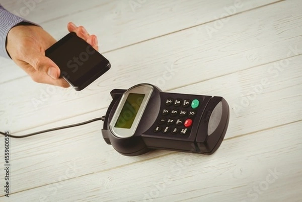 Obraz Contactless payment is happening on wooden countertop in flat design, with smartphone and terminal