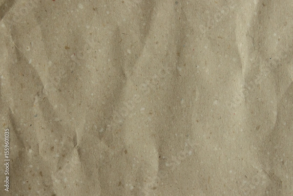 Obraz Close-up of a crumpled, light brown kraft paper texture. Its earthy tone