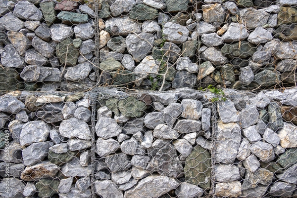 Obraz gabion wall, showcasing the texture of the grey stones and the wire mesh. The image highlights the detailed pattern and rugged nature