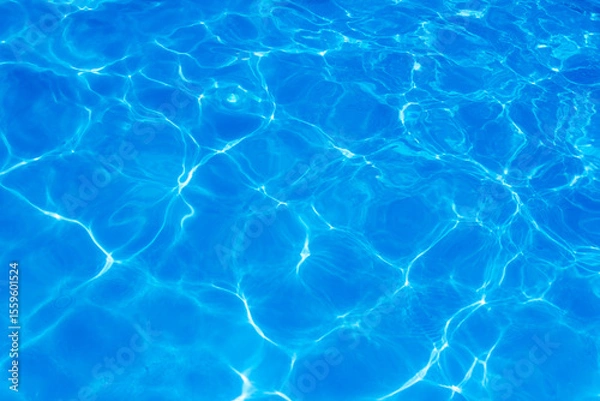 Obraz Clear blue swimming pool water surface with sunlight reflections creating abstract patterns and ripples, evoking a refreshing and tranquil summer vibe.