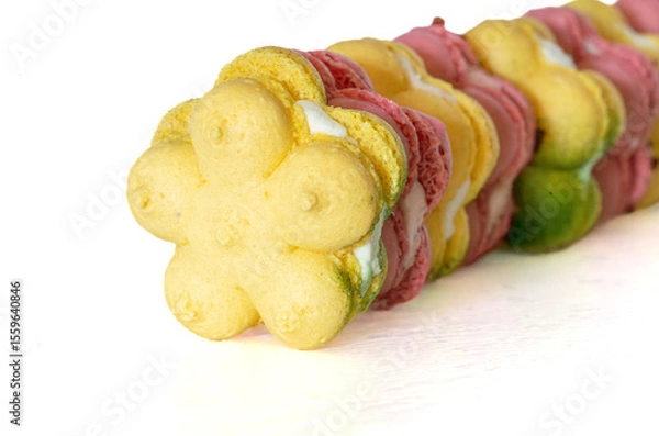 Fototapeta french macaron macaroon cookies in a curve row. bright strawberry pink and yellow green lemon, head on, close up, copy space