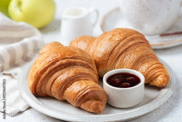 Fototapeta Two croissants and jam on plate, closeup view