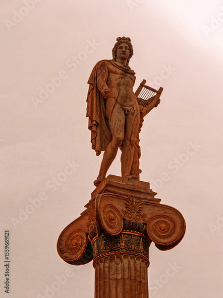 Obraz A majestic marble statue of Apollo, the ancient Greek god of music and fine arts, standing elegantly on a column while holding a lyre, symbolizing harmony and artistic mastery.