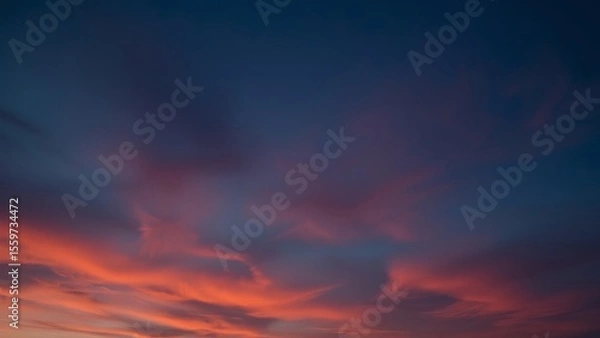 Fototapeta Magnificent sky at sunset painted in vibrant hues of orange, pink, and purple, with soft clouds drifting across the glowing horizon, creating a serene and breathtaking view of nature’s evening beauty